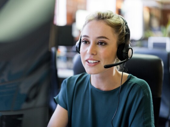 Smiling businesswoman wearing headset at office